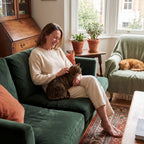 Happy cat owner relaxing with two calm cats at home